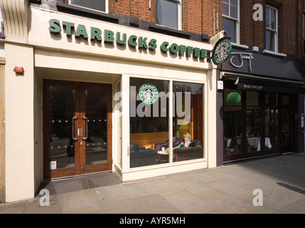 La donna nella finestra di Starbucks Coffee House mondi fine Kings Road Londra Foto Stock