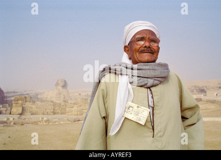 Dicembre 2000 Il Cairo Egitto curatore pone di fronte Sphinx presso le grandi piramidi Foto Stock