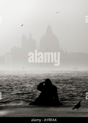 Silhouette di donna di fronte al San Giorgio Basilica su un nebbioso giorno di novembre, Venezia, Italia Foto Stock