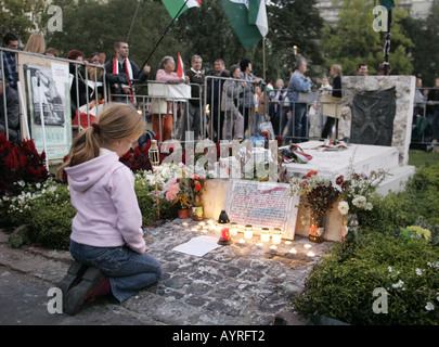 Bambina keeling a grave in piazza Kossuth a Budapest, Ungheria. Foto Stock