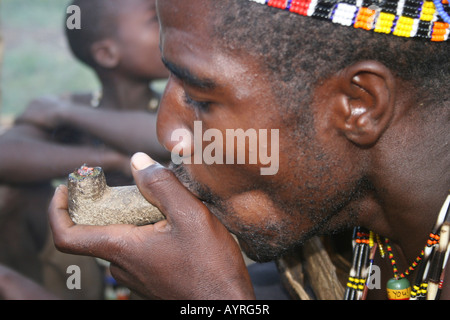 Africa Tanzania Lago Eyasi Hadzabe uomo fumo da un tradizionale tubo di argilla Foto Stock