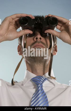 Imprenditore cerca attraverso il binocolo Foto Stock