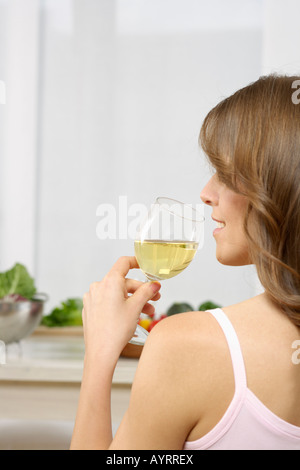 Metà donna adulta bere un bicchiere di vino bianco Foto Stock