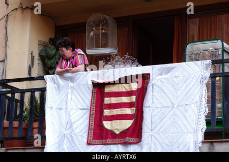 Signora anziana sul balcone circondato da gabbie di uccelli nel castello de empuries costa brava Catalogna Spagna catalana Foto Stock