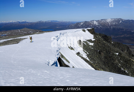 Escursionista, neve cornicioni, vasto paesaggio innevato, Jotunheinem National Park, Norvegia e Scandinavia Foto Stock