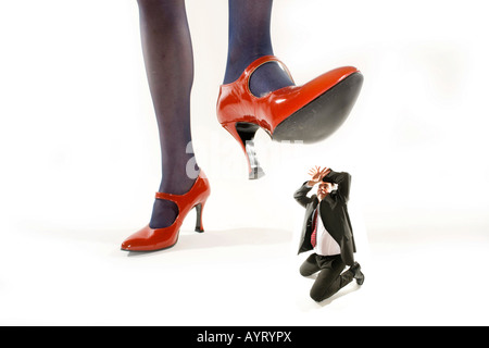 Woman in Red High Heels intensificazione su un shrunken man Foto Stock