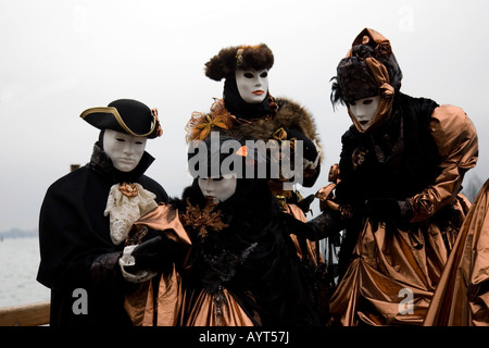 Quattro per il nero e marrone con costumi e maschere di Carnevale di Venezia il Carnevale di Venezia, Italia Foto Stock