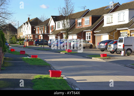 Villaggio strada di case principalmente semi-indipendenti con unità anteriori utilizzati per il parcheggio auto bidoni di riciclo vuoti sui verge Brentwood Essex UK Foto Stock