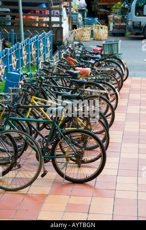 Fila di biciclette parcheggiate in rack esterno mall in Singapore Foto Stock