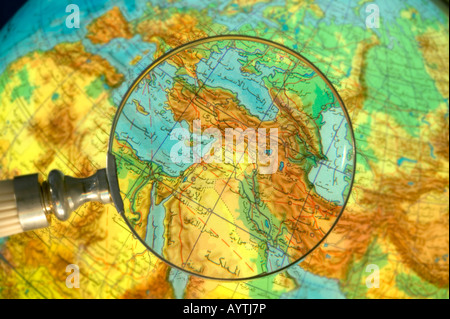 Parte del mondo Medio Oriente globe scritto in arabo visto attraverso la lente di ingrandimento Foto Stock