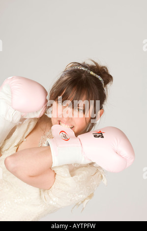 Una sposa rosa indossa guantoni da pugilato in una scherzosa guardare accordi prematrimoniali e sposarsi. Foto da Jim Holden. Foto Stock