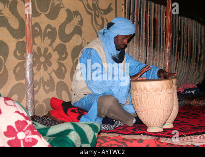 Musicista drumming in una tenda beduina a Merzouga Erg Chebbi, Marocco, Africa nord-occidentale Foto Stock