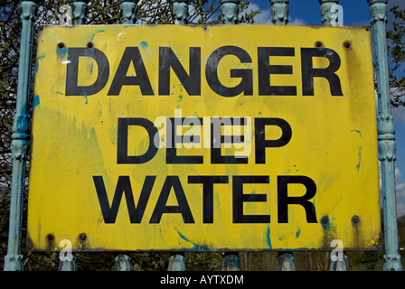 Pericolo in acqua profonda, un cartello di avviso con testo nero su sfondo giallo dal fiume Tamigi, Kingston, Surrey, Inghilterra Foto Stock