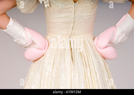 Una sposa rosa indossa guantoni da pugilato in una scherzosa guardare accordi prematrimoniali e sposarsi. Foto da Jim Holden. Foto Stock