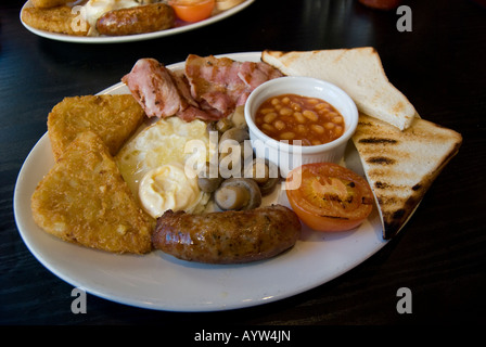 Una tradizionale prima colazione inglese di toast, uova, patate, pomodori, fagioli al forno, funghi e salsiccia. Foto Stock