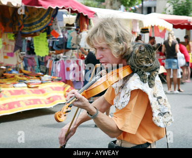 Un violino player del mercato con il suo gatto sulle spalle, Lorgues, Provenza, Francia Foto Stock