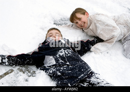 Un ragazzo e una ragazza a giocare nella neve invernale Foto Stock