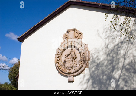 Emblema di pietra in rilievo sulla terrazza di estremità nei locali di vulcan vilage alloggiamento newton-le-Willows MERSEYSIDE REGNO UNITO Foto Stock