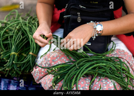 Isole Figi suva ragazza stringing fagioli nel mercato Foto Stock