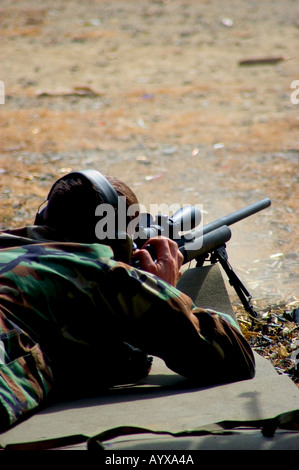 Rifleman in posizione prona sparare il fucile da cecchino sul poligono di tiro Foto Stock