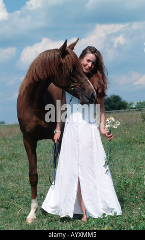 Junge Frau im weissen Hochzeitskleid mit Araber Vollblutpferd Maedchen und Pferde Araber modello posa Mensch und Pferd Foto Stock