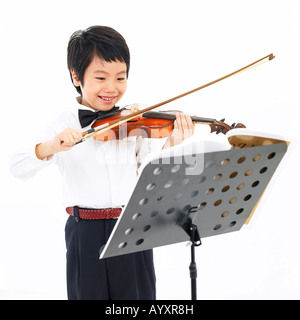 Un ragazzo giocando un violino con guardando nota musicale Foto Stock