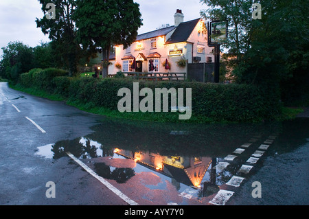 Il Brook Inn riflessa in una pozzanghera sulla strada vicino a Feckenham WORCESTERSHIRE REGNO UNITO Foto Stock