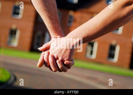 Coppia giovane tenendo le mani al di fuori casa Foto Stock