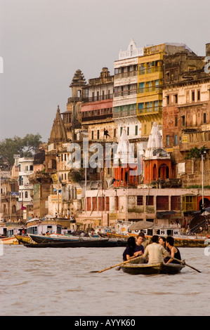 Barca turistica sul fiume Gange presso gli antichi ghat di Varanasi, Uttar Pradesh, India. Una vista panoramica dell'architettura storica dall'acqua. Foto Stock
