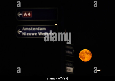 Cartello stradale e un crescente luna piena Foto Stock