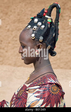 Mali, Gao. Una donna Songhay a Gao di mercato con un elaborato coiffure tipici della sua tribù. Le monete d'argento sono vecchi franchi francesi e British West Africa monete che risale a cento anni. Foto Stock