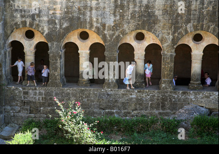 I turisti e i loro bambini giocare nel chiostro, l'Abbaye du Thoronet, Provenza, Francia Foto Stock