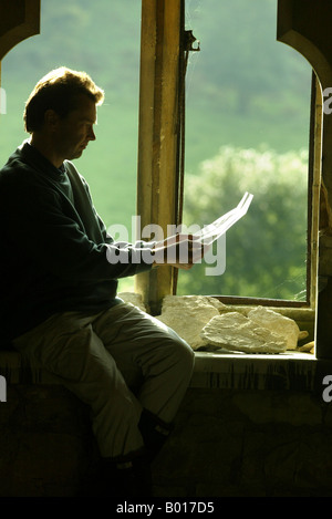 Un uomo si siede in una finestra di lettura del cantonale Foto Stock