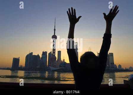 Albe su skyline come uomo anziano esercizi tai chi, il Bund, Shanghai, Cina Foto Stock