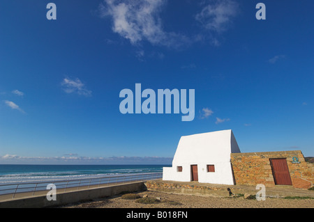 Il lungomare e Le Don Hilton verniciato bianco cottage per vacanze pietra miliare di St Ouen s Bay della parrocchia di San Pietro Jersey Isole del Canale della Manica UK Foto Stock