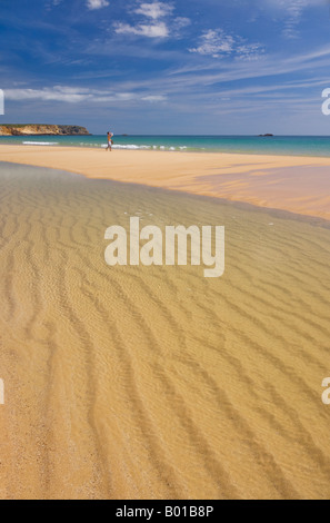 Giovane uomo in distanza sulla sabbia dorata della spiaggia di Martinhal Sagres Algarve Portogallo UE Europa Foto Stock