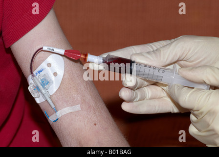 Prelievo di sangue da un picc line inseriti perifericamente cateteri centrali indossando guanti sterili Foto Stock