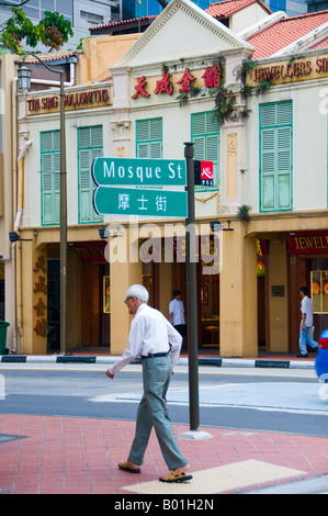 Senior uomo a camminare sul marciapiede del centro sulla Moschea Street a Chinatown di Singapore Foto Stock