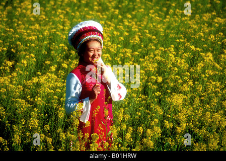 Bai nazionalità donna nel campo di semi di colza a Dali in primavera nella provincia di Yunnan Foto Stock