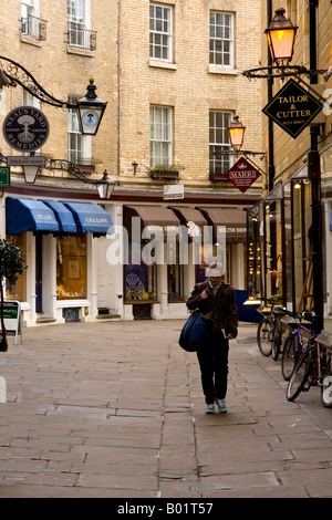 Una giovane donna camminare passato di moda boutique alla moda in rosa Crescent, Cambridge, Cambridgeshire, East Anglia, England, Regno Unito Foto Stock