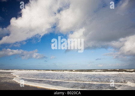 Le nuvole in un cielo blu al di sopra della marea in arrivo su Druridge Bay sulla costa Northumbrian, Northumberland, Inghilterra Foto Stock