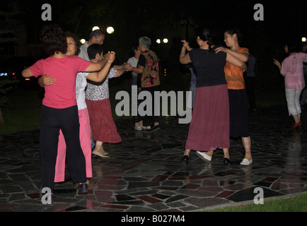 I residenti più anziani di un blocco di appartamenti a fare i balli nella serata estiva di Chaoyang Lu Pechino CINA Foto Stock