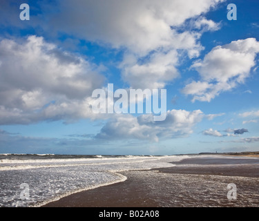 Le nuvole in un cielo blu al di sopra della marea in arrivo su Druridge Bay sulla costa Northumbrian, Northumberland, Inghilterra Foto Stock