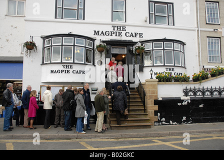 La coda di regolari al di fuori del famoso pesce e chip ristorante La gazza Cafe a Whitby North Yorkshire. Foto Stock