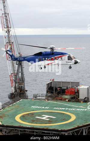 Un Bristows S-92 elicottero atterra su una piattaforma petrolifera nel Mare del Nord al largo della costa nord est della Scozia Foto Stock