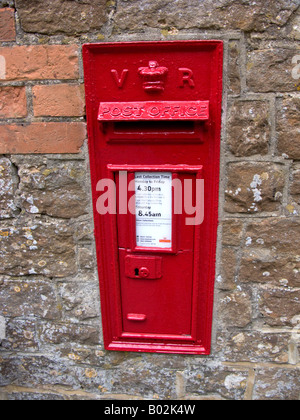 Un rurale postbox impostato nel muro di un edificio rurale in Surrey UK che reca la sigla della regina Victoria Foto Stock