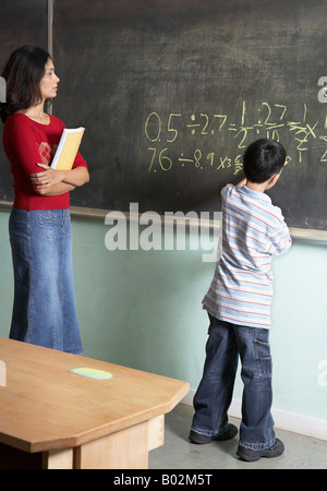 Ragazzo asiatico scrivere sulla lavagna Foto Stock