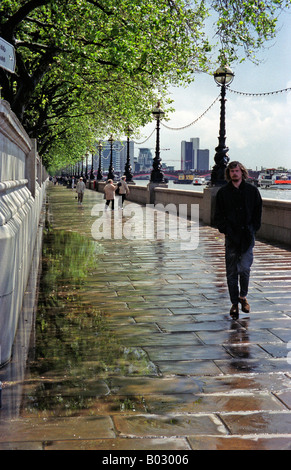 Un uomo cammina dopo la pioggia lungo la roccia umida sentiero lungo il fiume Tamigi a Londra, Regno Unito, 2001. Foto Stock