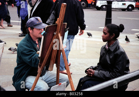 Un pittore di strada a Trafalgar Square a Londra, Regno Unito, dipinge il ritratto di un turista. Foto Stock