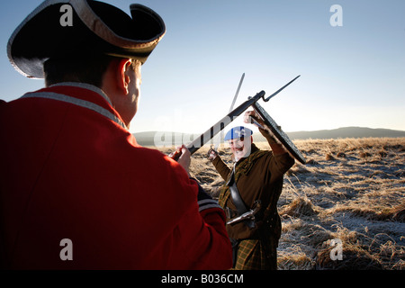 Duncan Cook vestito come un cappotto rosso officer e Mike Newcomen come Giacobita Clansman fare Battaglia di Culloden Visitor Center Foto Stock